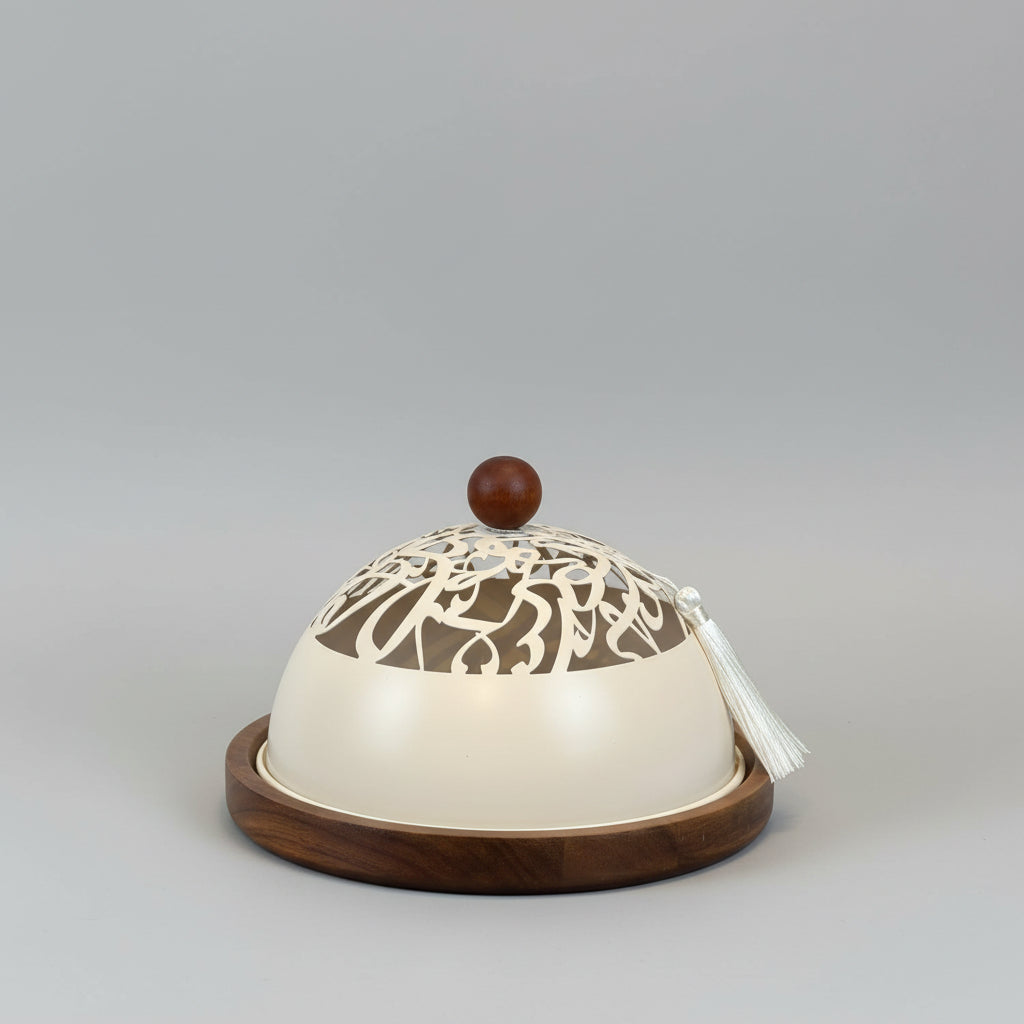 Decorative lamp with intricate design on a wooden base against a plain background