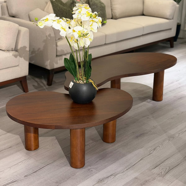 Living room with beige sofa, wooden coffee table, and decorative flowers.