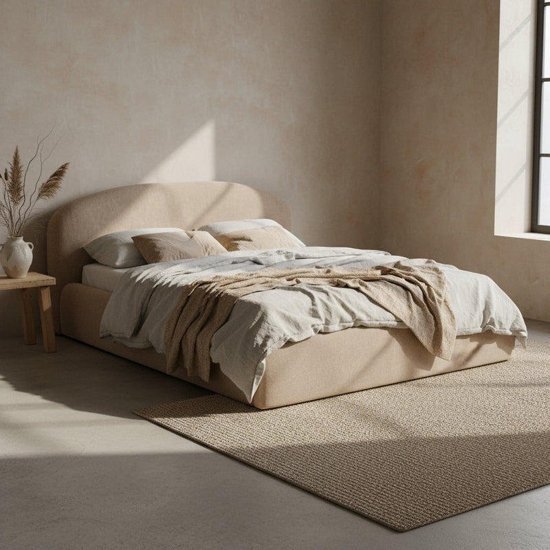Beige upholstered bed with white mattress on a white background